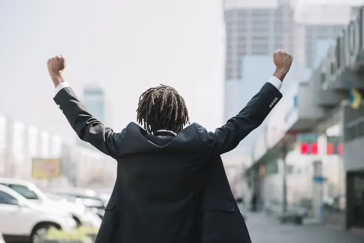 A student in a suit jubilating while celebrating a win