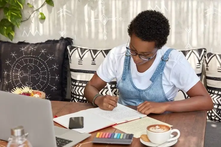 Female student listing down her budget expenses