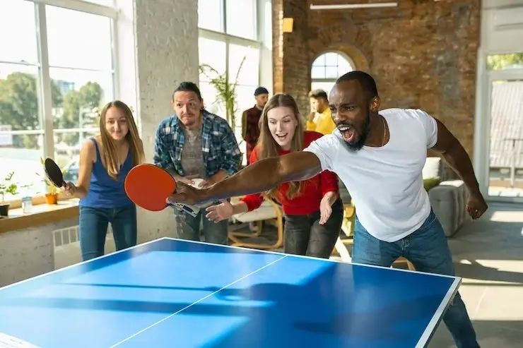 Young people playing table tennis after campus classes